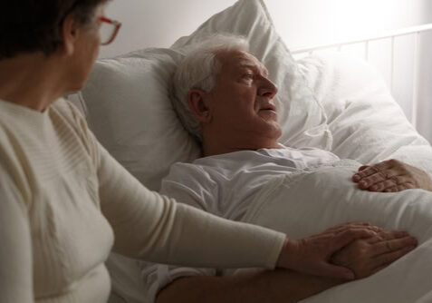 woman at bedside of dying man